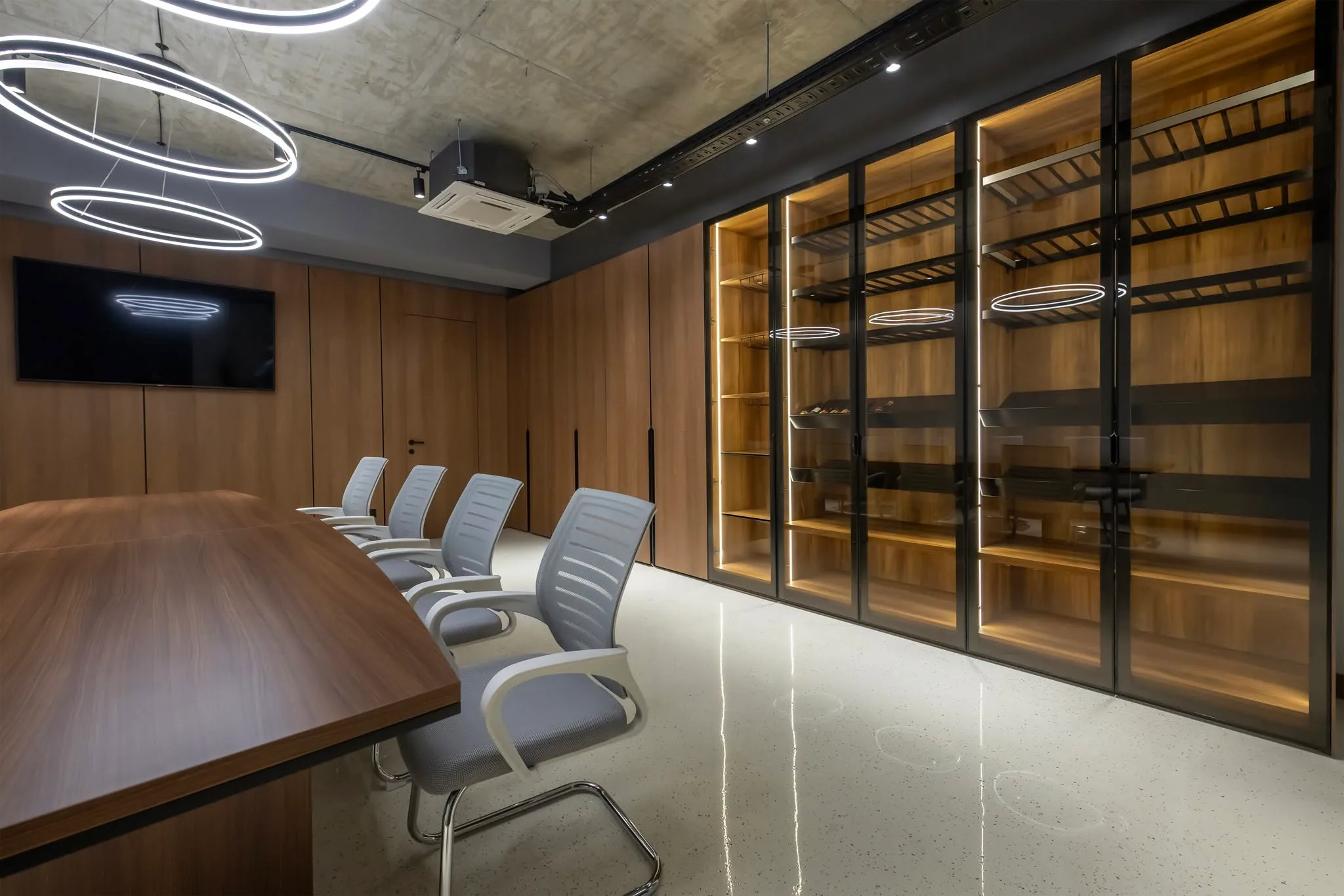 The finished boardroom of the same project, walnut units and a conference table